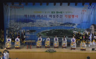 무대위의 사람들이 장구를 치며 여성주간 기념 행사를 진행하고 있는 모습