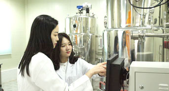 여자 연구원 두명이 배양 기계앞에 확인하는 모습