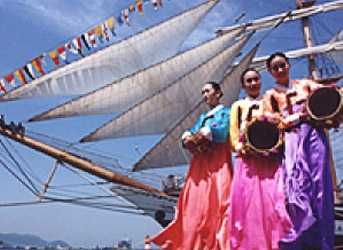 색색의 고운한복을 입은 3명의 여인이 배위에서 축제행사를 하는 모습