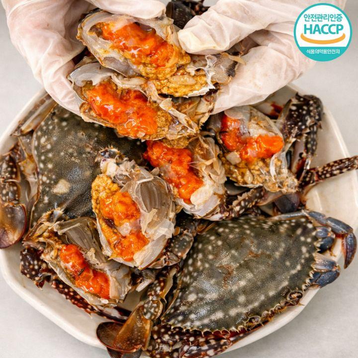 간장게장이 접시에 담겨있으며 반으로 잘려져 안쪽 살과 알이 맛있게 보이는 사진
