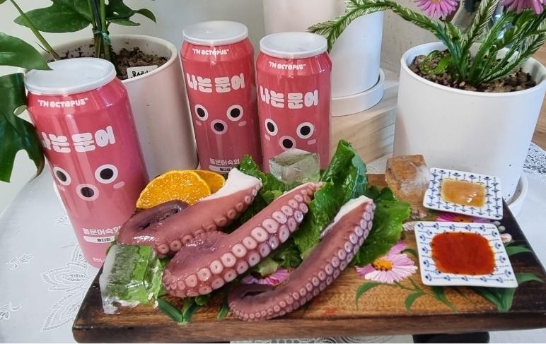 분홍색 문어 캔 용기와 나무 트레이 위에 차려진 돌문어 숙회