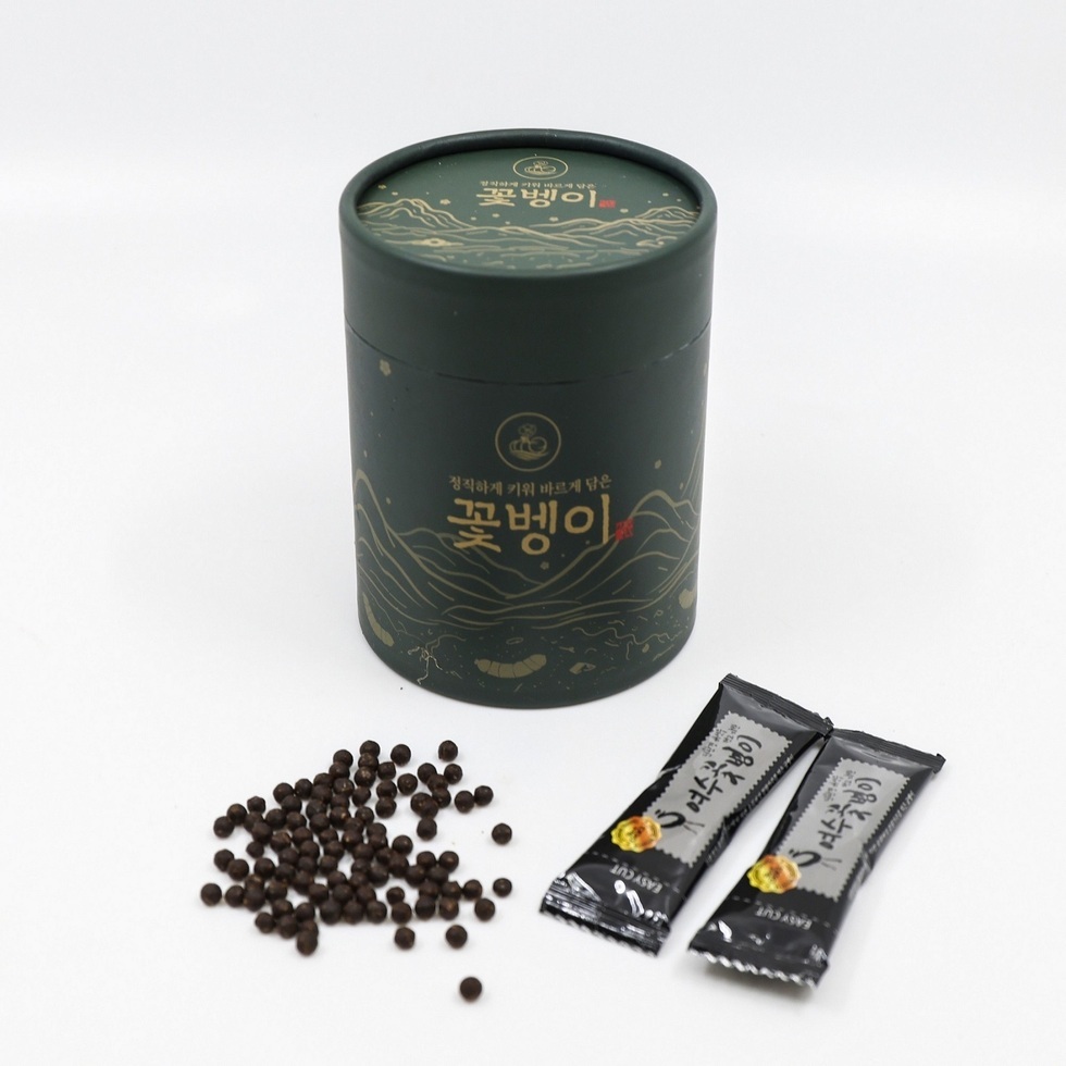 정직하게 키워 바르게 담은 꽃벵이' 원통형 용기와 여수 꽃벵이 스틱 포장 2개, 흩뿌려진 환 제품