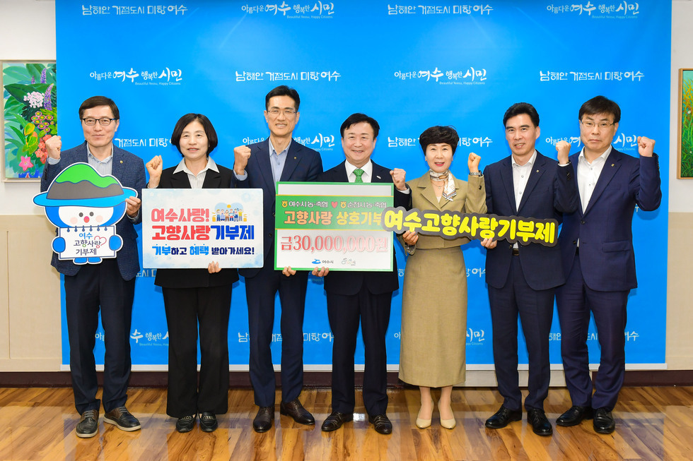 여수시청에서 여수사랑 고향사랑 기부제를 홍보하는 행사로, 여러 관계자들이 기부를 촉구하며 포즈를 취하고 있다.