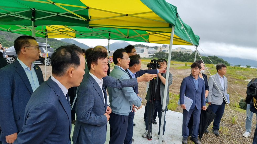 전남도지사와 여수시장이 같이 섬박람회 공사현장을 보면서 브리핑을 듣고 있는 모습이다.