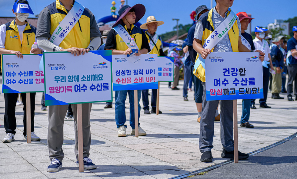 우리함꼐 소비해요 영양가득 여수 수산물, 건강한 여수 수산물 안심하고 드세요! 등의 팻말들 들고 있는 시민들의 모습 