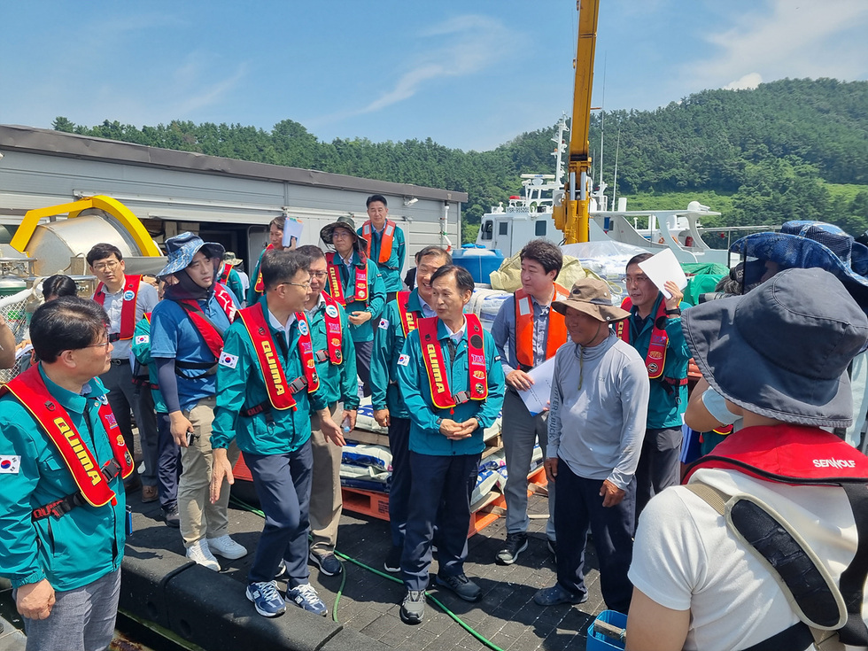 초록색 점퍼와 빨간색 슬로건을 걸친 관계기관 사람들과 정기명 여수시장과 이야기를 나누고 있는 모습