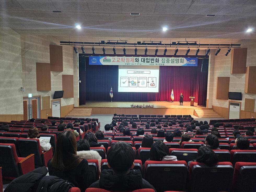 고교학점제와 대입변화에 대한 설명회가 진행되고 있는 모습으로, 강사가 무대에서 발표하고 있으며, 청중이 강의를 듣고 있다.