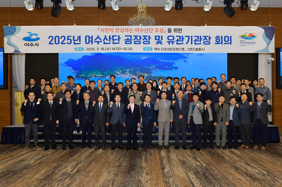 여수시에서 2025년 여수산단 공장장 및 유관기관장 회의가 열리고 있으며, 참석자들이 단체 사진을 찍고 있다.