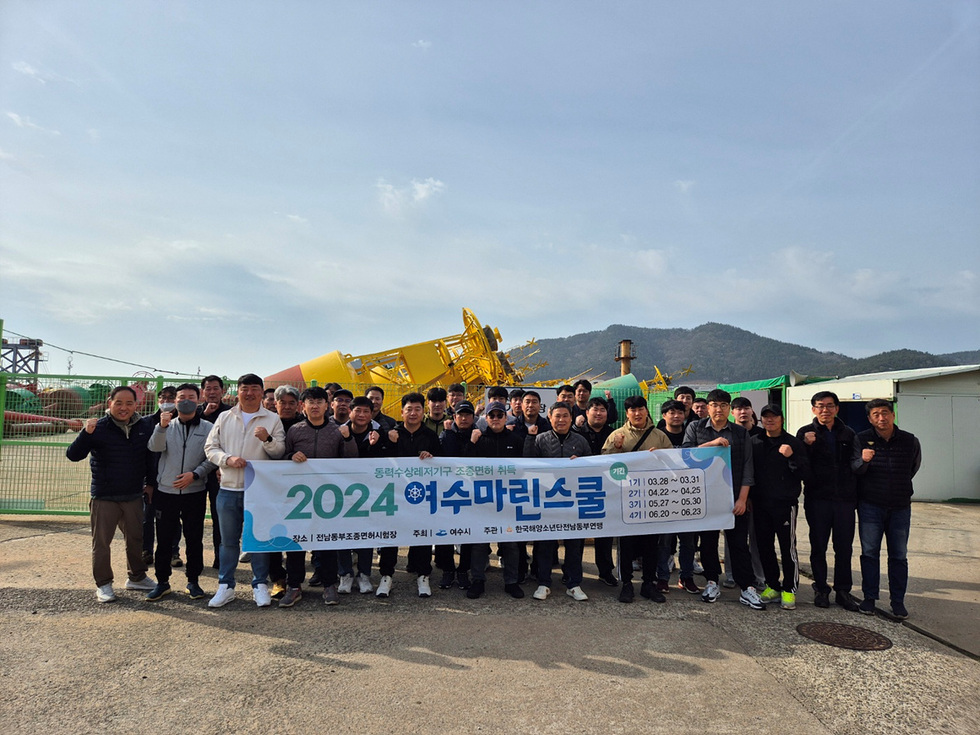 2024 해수마리스크 행사에 참여한 사람들이 단체로 사진을 찍고 있으며, 배경에는 해양 장비가 보인다.
