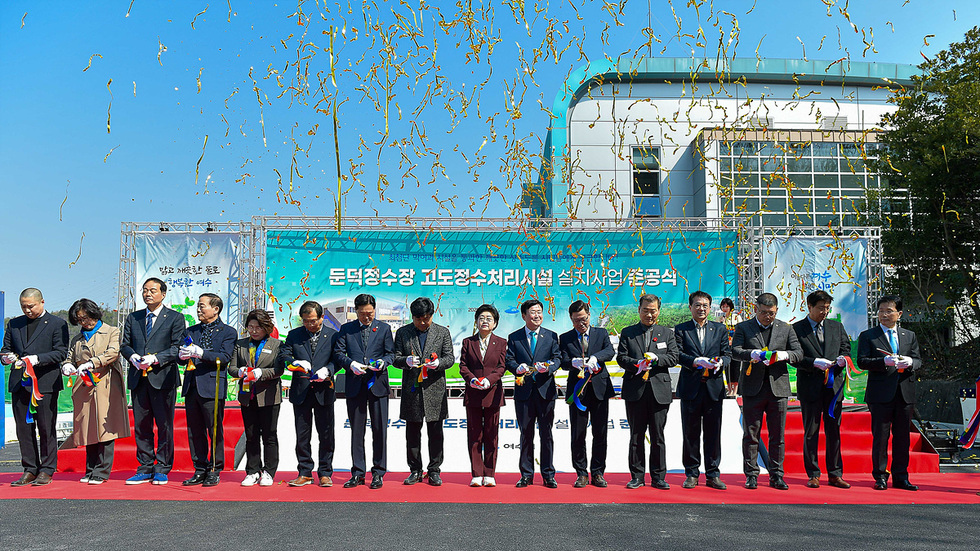 돈덕정수장 고도정수처리시설 준공식에서 여러 인사들이 리본을 들고 기념 촬영을 하고 있다.