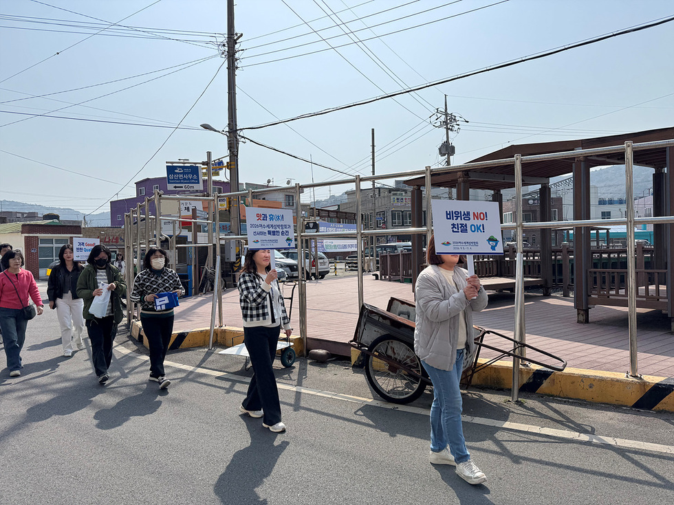 여성들이 거리에서 비키세요 NO! 친정 OK!라는 문구가 적힌 현수막을 들고 행진하고 있다.