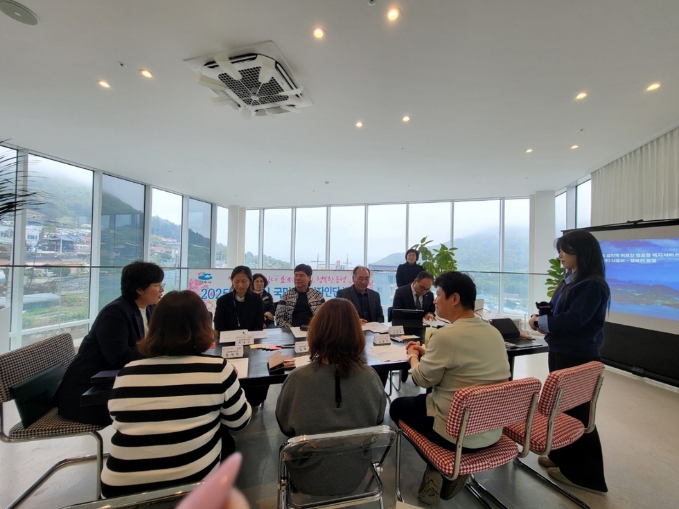 여수시 국민정책디자인단 발대식 회의 현장. 단원들이 원탁에 둘러앉아 논의하고 있으며, 스크린과 발표자가 함께하는 모습.