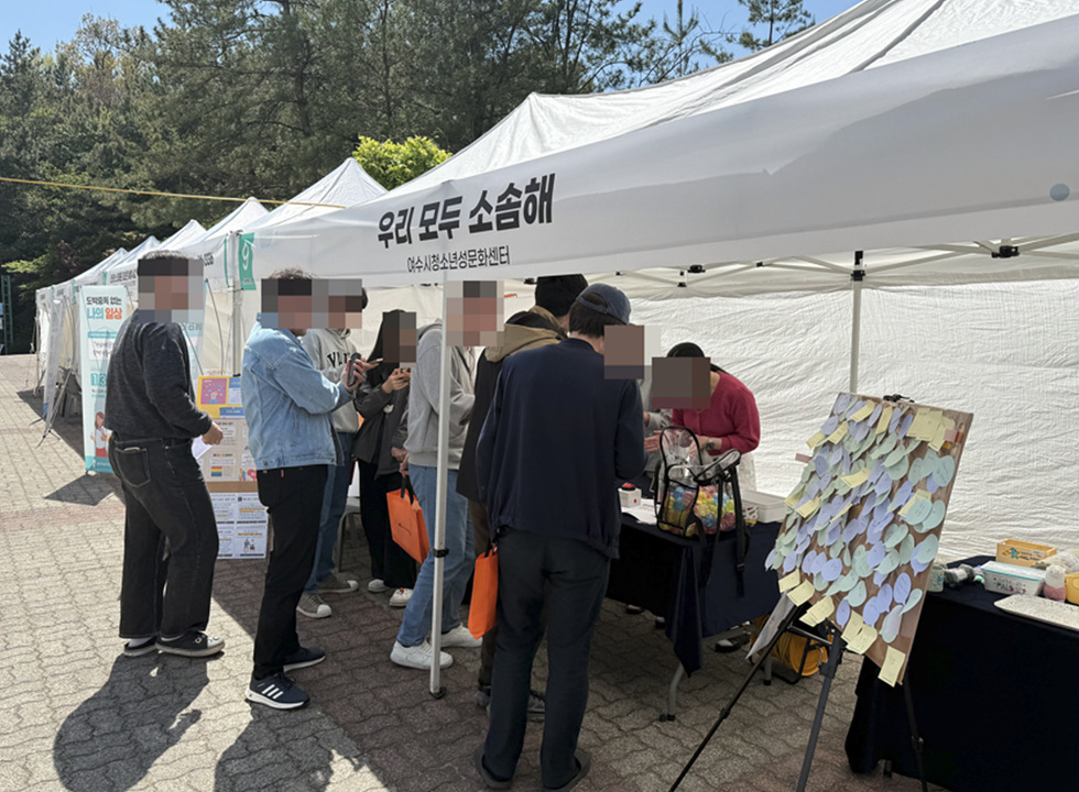 여수시청소년성문화센터 부스에서 사람들이 모여 대화하며 활동에 참여하고 있다.
