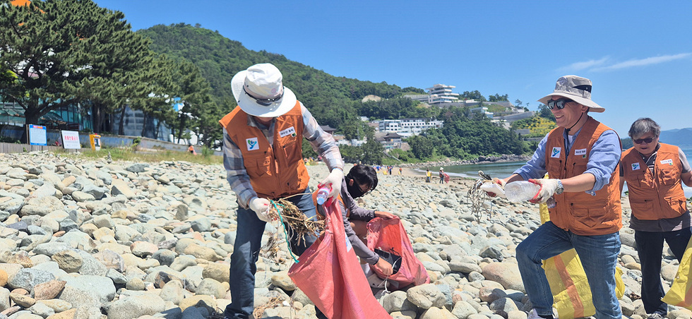자원봉사자들이 해변에서 해양쓰레기를 수거하고 있는 모습이다.