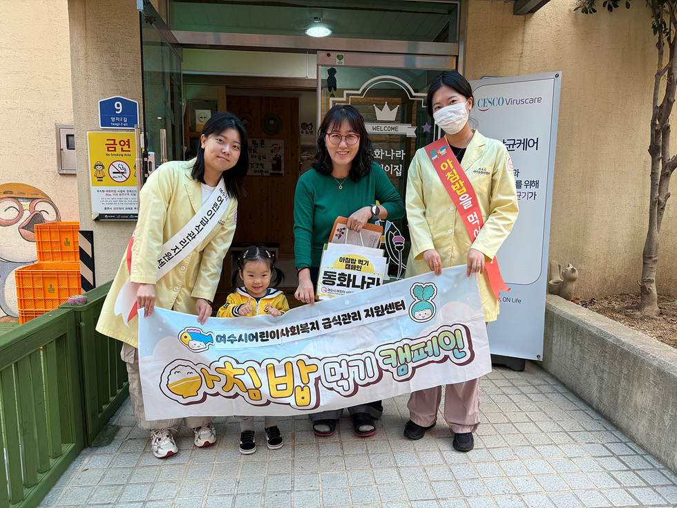 여수시 어린이사회복지급식관리지원센터 관계자들이 아침밥 먹기 캠페인 현장에서 어린이와 함께 기념사진을 찍고 있다.