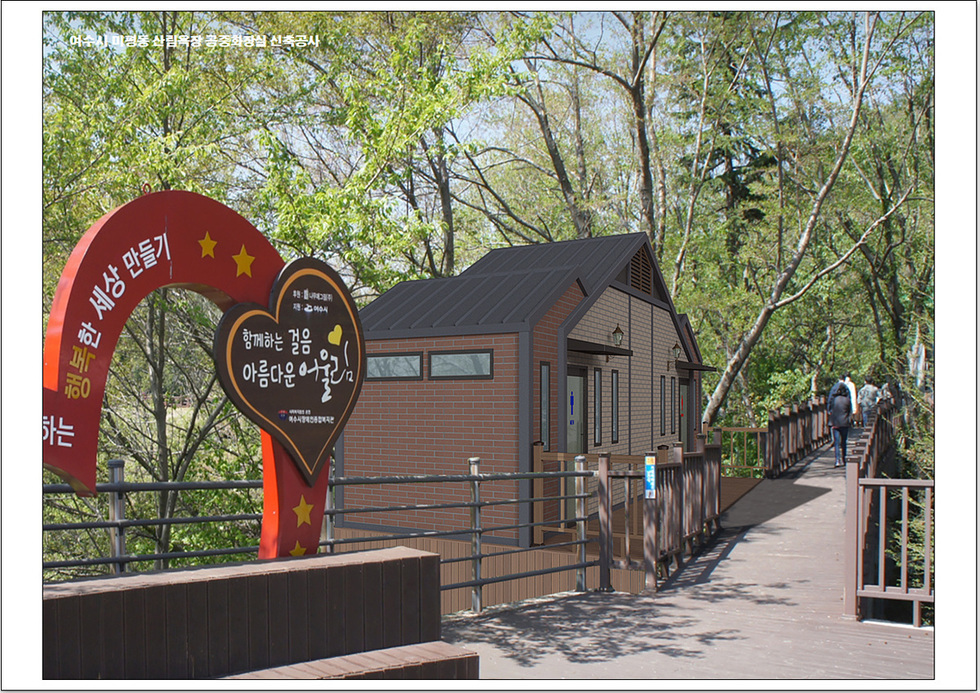여수 미평산림욕장에 새로 건축된 화장실과 함께하는 걸음 아름다운 여수라는 문구가 적힌 현수막이 보인다. 산림욕장을 이용하는 시민들이 보인다.