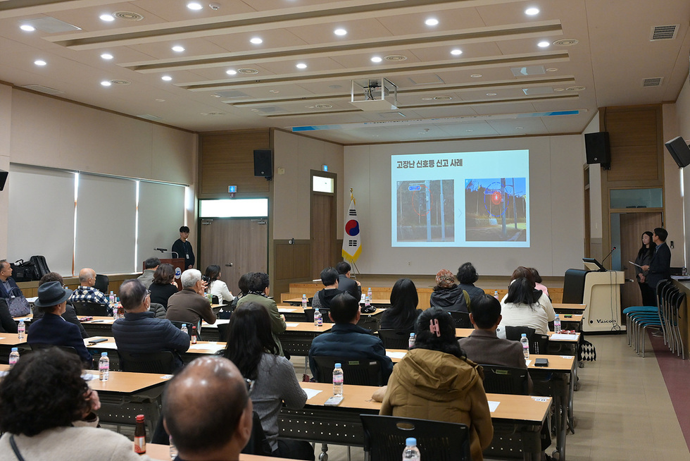 강의실에서 안전보안관들이 ‘고장난 신호등 신고 사례’가 표시된 화면을 보며 교육을 듣는 모습.