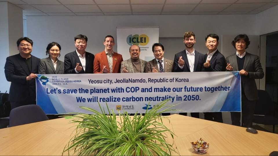 여수시에서 탄소 중립을 목표로 하는 COP 회의에 참석한 여러 인사들이 현수막을 들고 포즈를 취하고 있다.