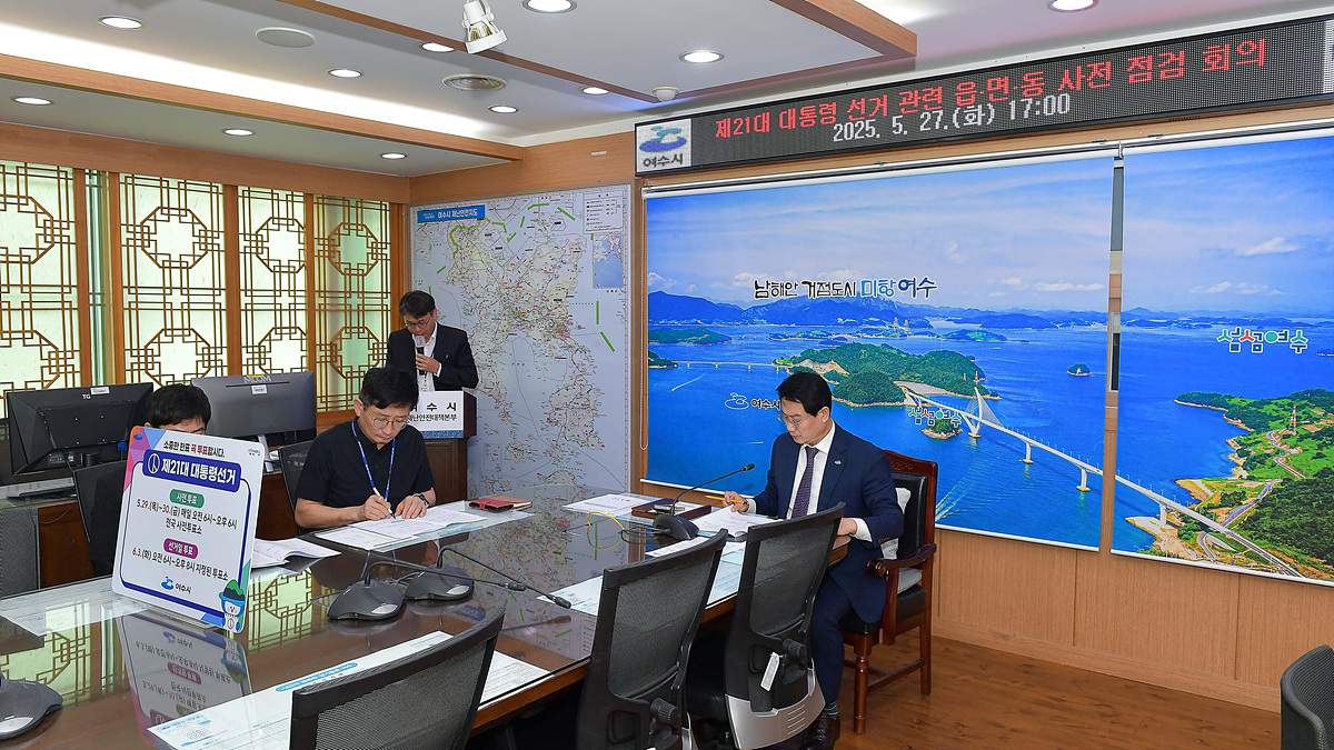 2025년 5월 27일 거제시에서 제21대 대통령 선거 관련 음독 사전 접견 회의가 진행되고 있는 모습이다. 회의실에는 지도와 해양 사진이 배경으로 보인다.