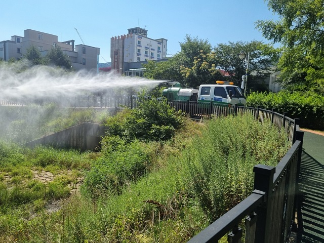여수시, 일본뇌염 경보 발령에 따른 방역 활동 강화 - 취약지역 집중 방역 실시… 모기 매개 감염병 예방 행동수칙 준수 당부와 관련하여 하천부분에 방역차가 방역을 하고있는 사진이다.