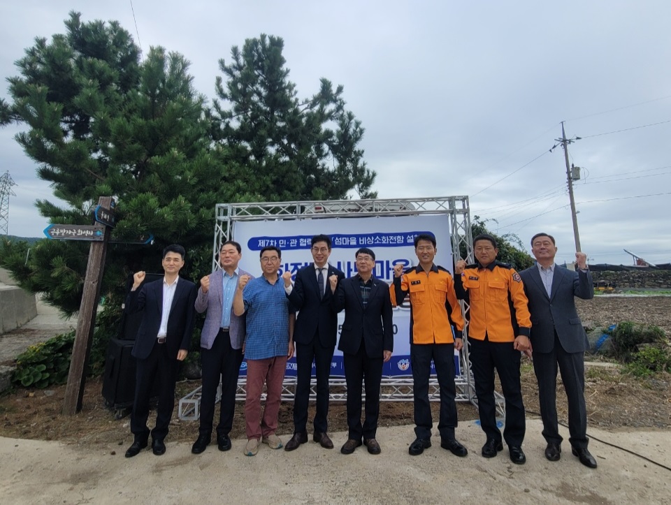 여수시 화정면에서 비상소화전함 설치를 기념하는 준공식에 참석한 관계자들이 기념사진을 찍고 있다.