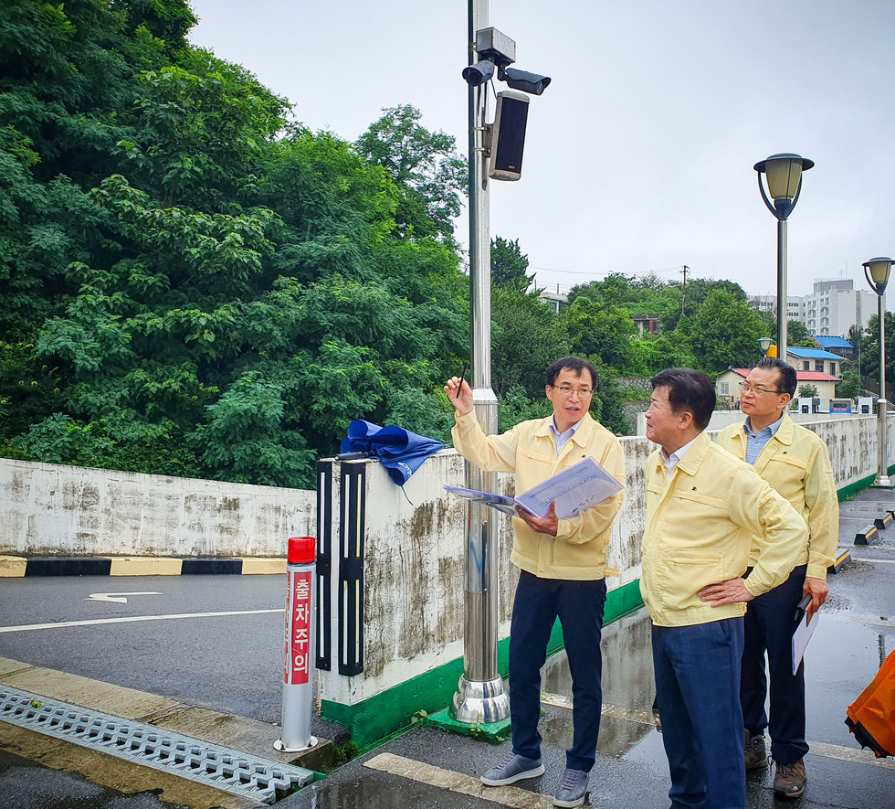 여수시장이 수해현장에 방문하여 피해 입은곳을 바라보며 피해상황 보고를 듣고 있는 사진이다.