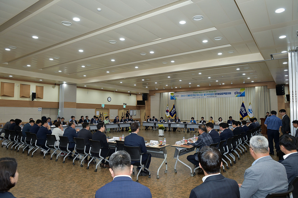 큰 회의장에서 여수시청 관계자와 더불어 민주당 관계자들이 회의 하고 있는 모습