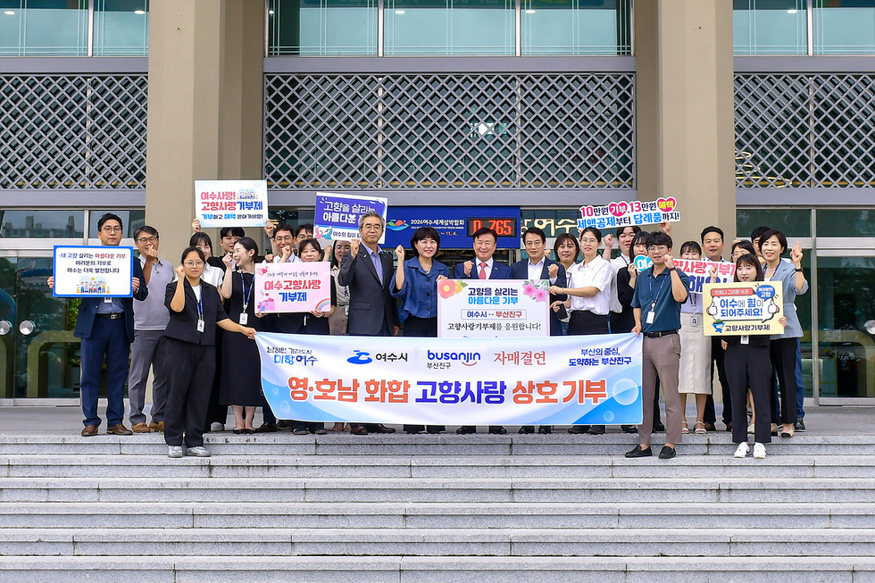 [여수사랑!고향사랑 기부제! 기부하고 혜택 받아가세요! / 새 고향 살리는 아름다운 기부, 여러분의 기부로 여수는 더욱 발전합니다. / 여수고향사랑 기부제/ 고향을 살리는 아름다운 기부 / 고향을 살리는 아름다운 디부 여수시··부산진구 고향사랑기부제를 응원합니다! /10만원 기부, 13만원 혜택 세액공제부터 답례품까지! 여수에 힘이 되어주세요! 고향사랑기부제! / 남해안 거점도시 미항여수 /여수시 / 부산진구 / 자매결연 / 부산의 중심 도약하는 부산진구 / 영.호남 화합 고향사랑 상호기부] 각 현수막 또는 판낼를 들고 여수시와 부산진구 직원과 함께 20명의 단체사진을 찍은 모습