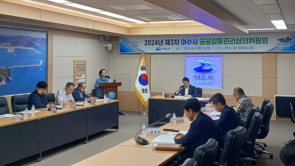 남해거점도시 미항 여수 2024년 제3차 여수시 공공갈들관리심의위원회 여수시 일시 | 2024.8.8(목) 14:00 장소| 여수시청 상황실(2층) [2026 여수세계섬박람회] 여수시 1명의 진행자와 7명의 사람들이 위원회를 진행하고 있는 모습