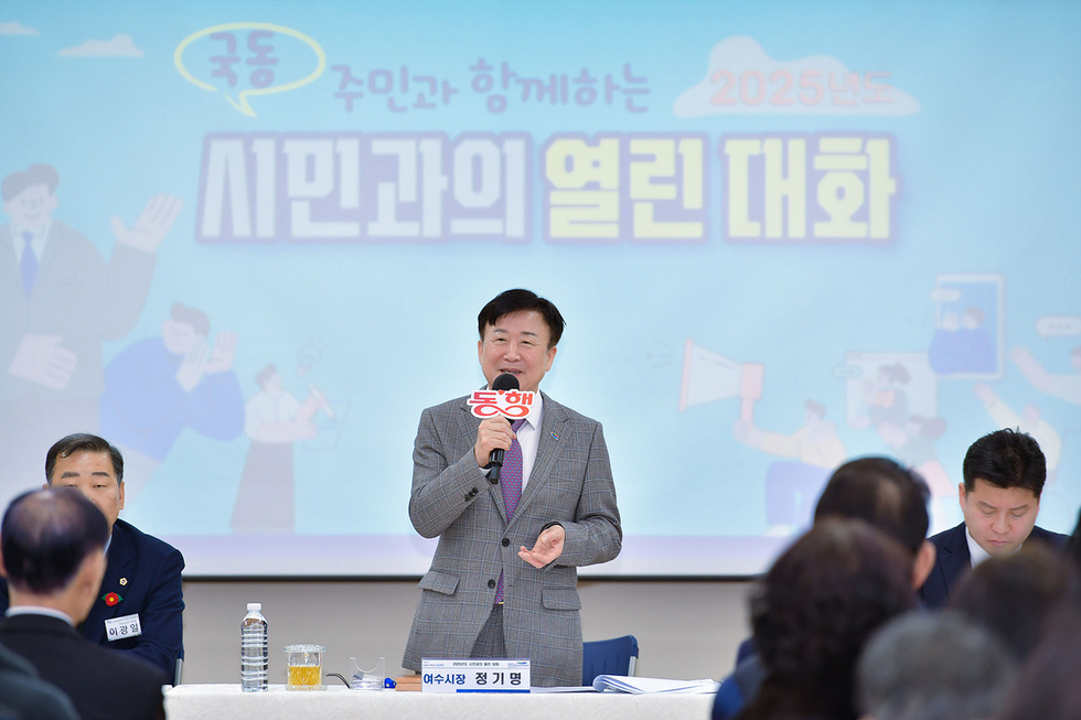 여수시장에서 정기명이 시민과의 열린 대화 행사에서 발언하고 있다. 배경에는 행사 주제가 적힌 현수막이 보인다.