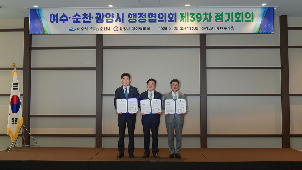 여수시, 순천시, 광양시의 행정협의회 제39차 정기회의에서 세 명의 참석자가 서류를 들고 포즈를 취하고 있다.