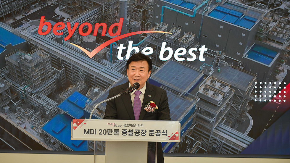 한 남성이 MDI 20만톤 증설공장 준공식에서 연설하고 있으며, 배경에는 공장 이미지와 함께 'beyond the best'라는 문구가 보인다.