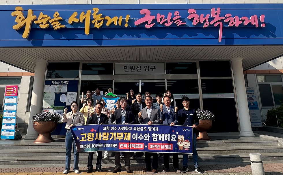 여수시청 앞에서 고향 사랑 기부제를 홍보하는 행사에 참여한 사람들 모습. 참석자들이 기부를 독려하는 현수막을 들고 있다.