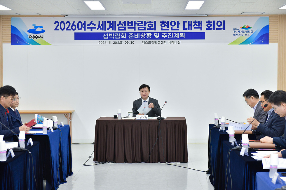 여수시에서 2026 여수세계섬박람회 현안 대책 회의가 열리고 있으며, 회의 중 한 참석자가 자료를 들고 있다.