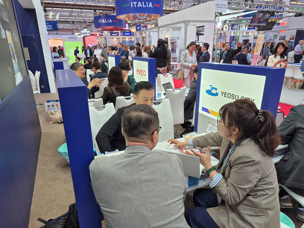 여수시 부스에서 사람들이 대화하며 정보를 교환하는 장면이다.