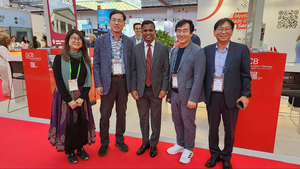 GCB 부스 앞에서 다섯 명의 사람들이 함께 서 있는 모습으로, 행사에 참여하고 있는 장면이다.