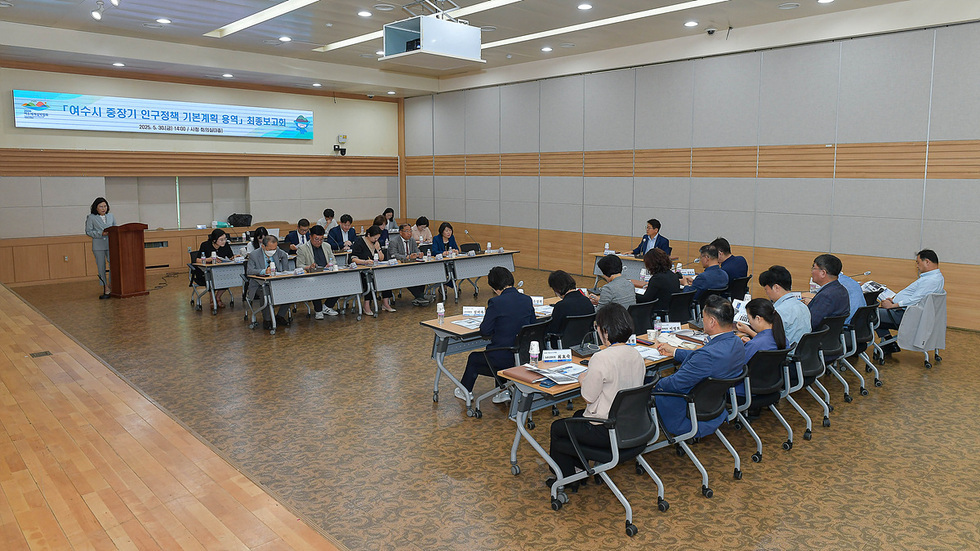 여수시청에서 중장기 외국정책 기본계획 용역 최종보고회가 진행되고 있으며, 발표자가 강단에서 발표하고 있고 참석자들이 회의에 집중하고 있다.