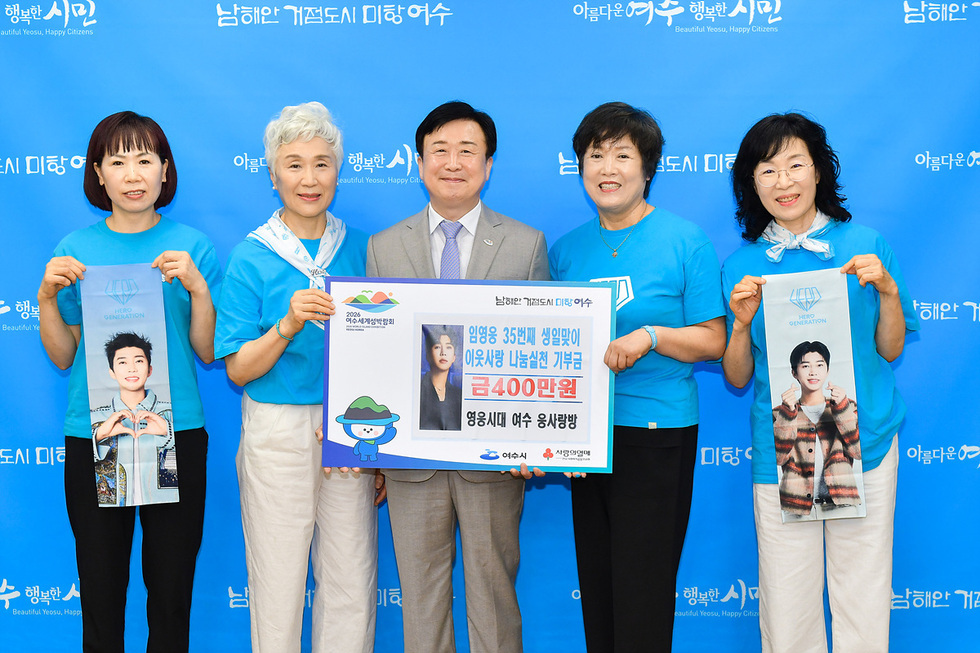 여수에서 기부금 전달식을 가진 네 명의 여성과 한 남성이 기념사진을 찍고 있다. 여성들은 기부금과 관련된 현수막을 들고 있다.