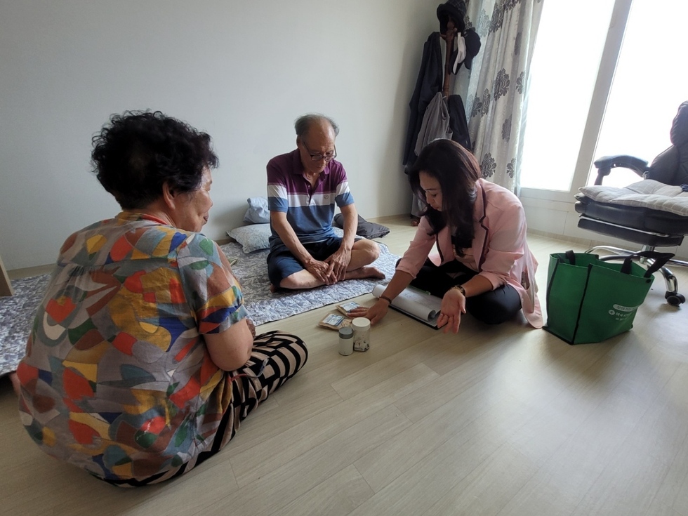 방문간호사가 부부 가정을 찾아가 약과 건강보조제를 설명하며 건강 상담을 진행하는 장면