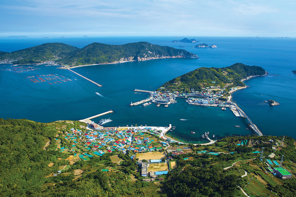 여수 삼산면 서도 덕촌 일대의 전경. 섬마을이 푸른 산과 바다에 둘러싸여 있으며, 넓은 항구와 여러 부두 시설이 보인다