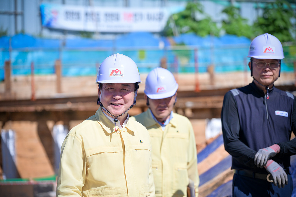 노란 작업복과 안전모를 착용한 정기명 여수시장이 건설 현장을 방문해 근로자 안전관리 실태를 점검하는 모습