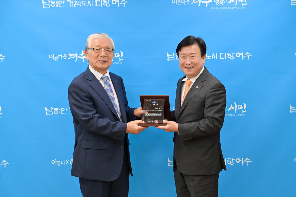 두 남성이 감사패를 주고받고 있는 장면으로, 배경에는 아름다운 여수 미항 시민이라는 문구가 적혀 있다.