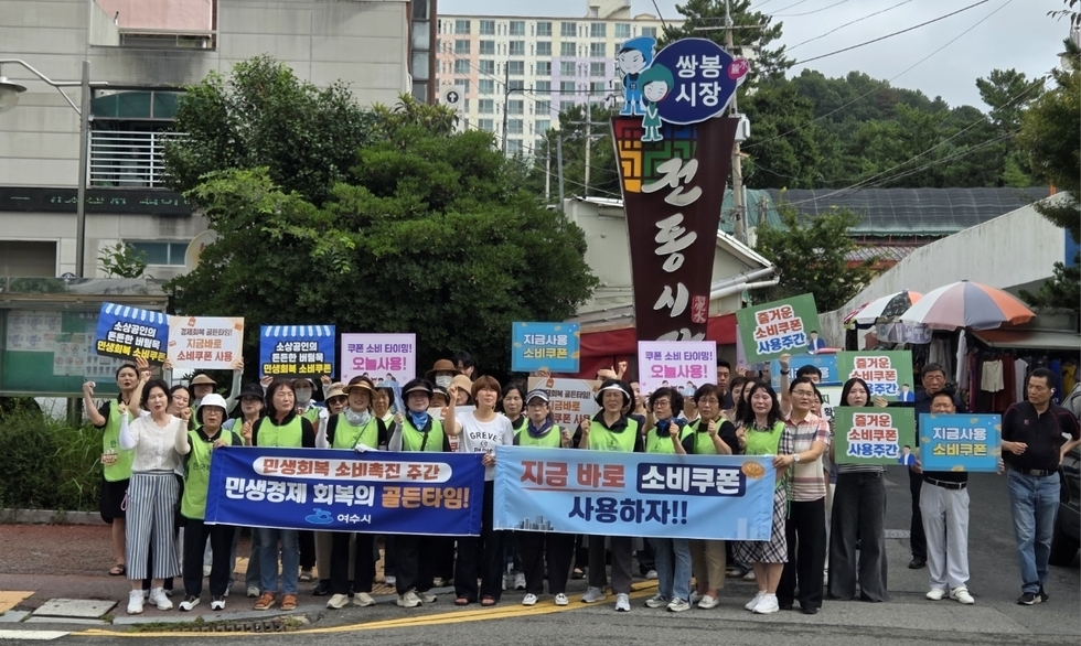 여수시에서 소비촉진을 위한 캠페인에 참여한 시민들이 소비쿠폰 사용을 촉구하는 피켓을 들고 있다.