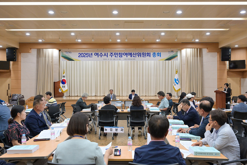 여수시에서 2025년 주민참여예산위원회 총회가 열리고 있으며, 여러 위원들이 회의에 참석하고 있다.