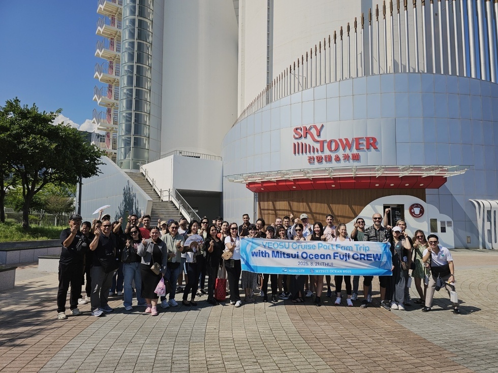 여수 크루즈 포트 팸 트립에 참여한 사람들 50명이 스카이타워 앞에서 기념사진을 찍고 있다.