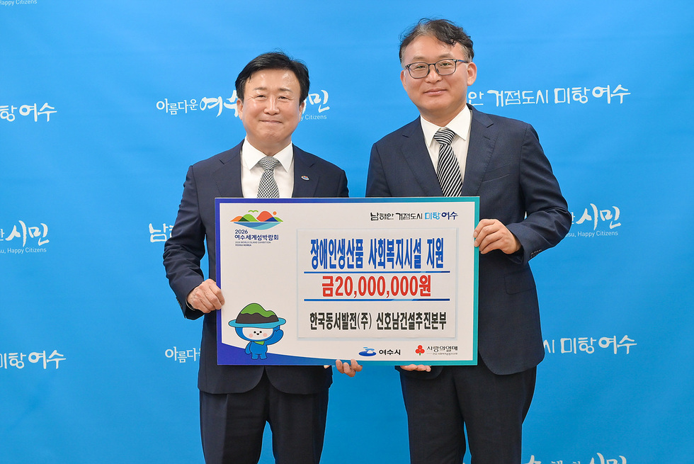 여수시청에서 장애인 생산품 사회복지시설 지원을 위한 2000만원 기부식이 진행되고 있다. 두 남성이 기부금 현판을 들고 있다.