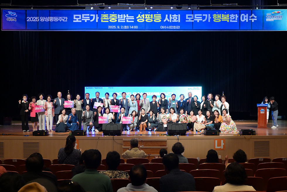 여수시민회관에서 열린 2025 양성평등주간 행사에서 참석자들이 기념사진을 찍고 있다. 배경에는 행사 주제가 적힌 현수막이 걸려 있다.