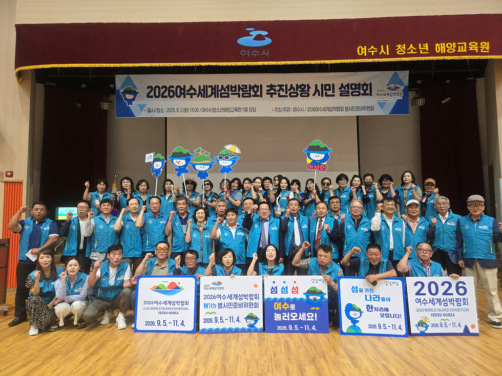 여수에서 2026 세계섬박람회 추진상황 시민 설명회에 참석한 사람들로, 참가자들이 손을 들어 응원하는 모습이다.