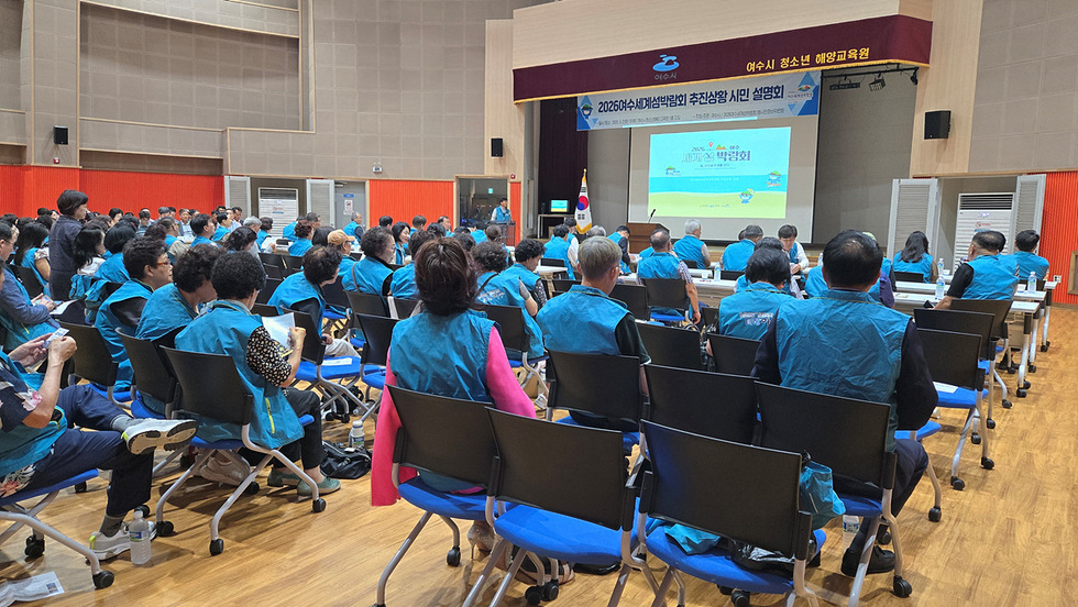 여수시청소년 예양교육원에서 2026여수세계섬박람회 추진상황 시민 설명회가 진행되고 있다. 참석자들은 푸른 조끼를 착용하고 발표를 경청하고 있다.