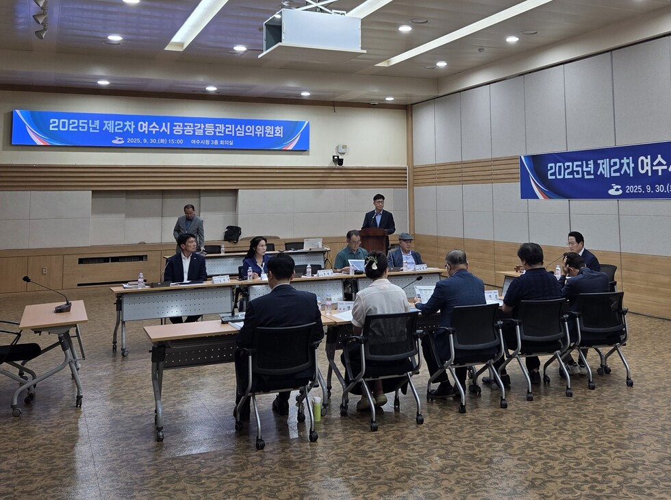 여수시청 회의실에서 2025년 제2차 공공갈등관리심의위원회가 열리고 있으며, 다양한 분야의 위원들이 참석해 갈등 예방 방안을 논의하는 장면이다.